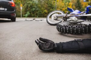 motorcyclist laying in parking lot with the downed motorcyclist beside