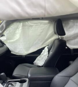 Interior of SUV with tarp covering broken windows after car accident