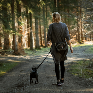 woman walking dog on leash on path