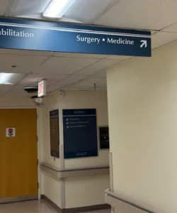 hallway in hospital with signage pointing toward surgery